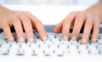 Hands typing on a keyboard.